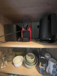 a shelf with a microwave and some plates and dishes at Esquinandra - Chambre randonneurs et cyclistes - GR 223 - Quai des Ormes in Barneville-Carteret