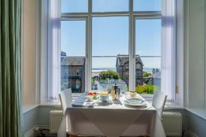 a table in a room with a large window at Corner Beech House in Grange Over Sands +28 photos
