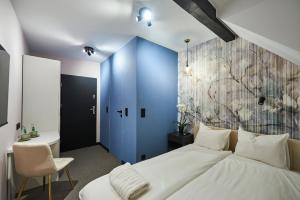 a bedroom with a large bed and a blue wall at Villa Scolia in Niechorze