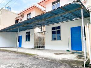 un edificio con una puerta azul a un lado en Homestay Nomad Kuala Terengganu, en Kuala Terengganu