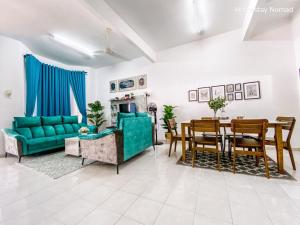 Una sala de estar con un sofá verde y una mesa. en Homestay Nomad Kuala Terengganu, en Kuala Terengganu