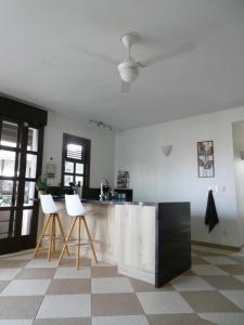 a kitchen with two white bar stools in a room at Blue Bay Villa Bon Bini. in Willemstad