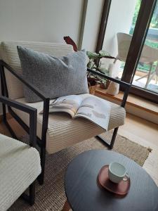a coffee table with an open book on a chair at Rila Mountain Design Studio, Borovets, Shiroka poliana 216 in Borovets