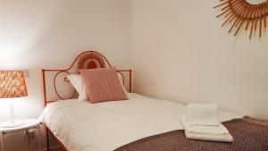 a small bedroom with a white bed and a lamp at CASA ANDORINHAS in Fontainhas +2 photos