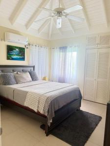 a bedroom with a bed and a ceiling fan at Luxury villas Oceanic View - Richmond Estate in Richmond