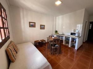 a living room with a couch and a kitchen with a table at Nono Huasi Departamentos in Cafayate