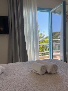 a bedroom with a bed with two towels on it at Olea Blue in Skiathos