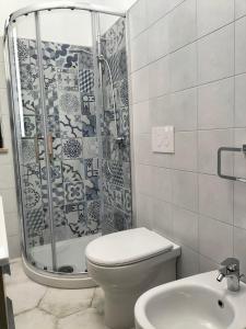 a bathroom with a shower and a toilet and a sink at Casa vacanze Acquamarina in Portopalo