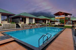 a swimming pool in front of a resort at Alokik Sharanam Zinc Journey by The Fern, Mahabaleshwar in Mahabaleshwar