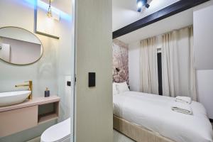 a bathroom with a bed and a sink and a mirror at Villa Scolia in Niechorze