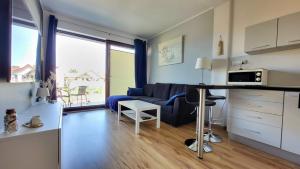 a kitchen and living room with a couch and a table at ApartMorze Apartamenty na Leśnej in Jastarnia