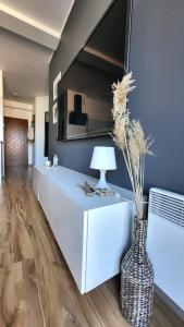a living room with a vase with a plant in it at ApartMorze Apartamenty na Leśnej in Jastarnia