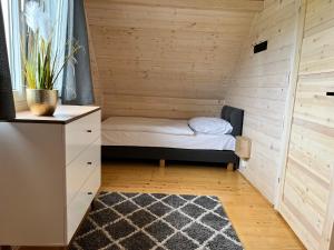a small room with a bed in a wooden wall at Domki Liza in Dziwnów