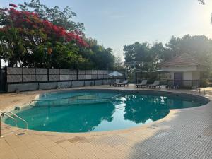 a swimming pool in a yard with tables and chairs at Bangalore Hideaway 1BHK Spanish villa Casa Rio in Denkanikota