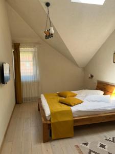 a bedroom with a large bed with yellow pillows at Cozy Apartment in Braşov