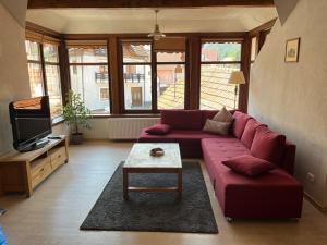 a living room with a red couch and a table at Cozy Apartment in Braşov