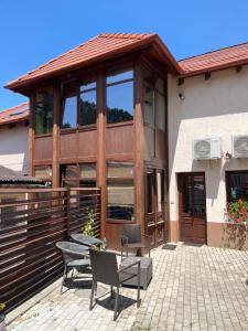 a house with a patio with two chairs at Cozy Apartment in Braşov