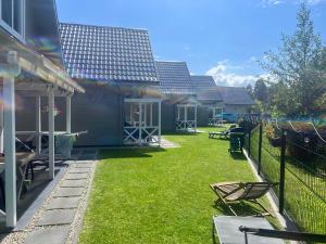 a yard with chairs and a fence and a house at Domki Liza in Dziwnów +29 photos