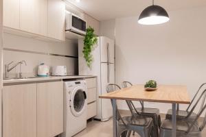a kitchen with a table and a white refrigerator at Fliphaus Moreno 550 'A' Loft with Pool in Plaza de Mayo in Buenos Aires +1 photo