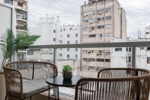 balcón con mesa, 2 sillas y ventana en Fliphaus Moreno 550 'B' Loft with Pool in Plaza de Mayo, en Buenos Aires