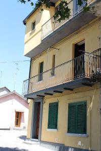 Casa Ela في سيرا سان برونو: مبنى اصفر بأبواب خضراء وبلكونه