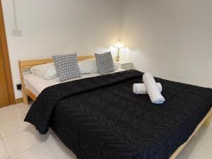 a bedroom with a large bed with a black blanket at RAHIMA GUEST HOUSe 2 in Rome