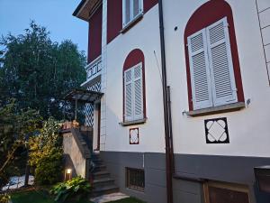 a building with two windows and a staircase at Villa WOLF - A 1919 original Swiss Villa with Garden near Como in Balerna