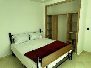 a bedroom with a bed and a book shelf at Sany Beach in Martil