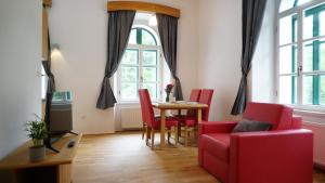 a living room with a table and red chairs at Snežnik castle estate in Stari Trg pri Ložu