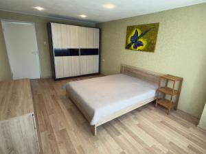 a bedroom with a bed and a cabinet and wooden floors at Soldino Apartments in Narva