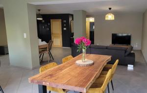 a dining room table with a vase of flowers on it at Sous le clocher  +12 photos