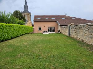a house with a stone wall and a yard at Sous le clocher 