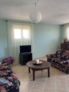 a living room with a coffee table and a tv at Kipoossa in Mesochórion