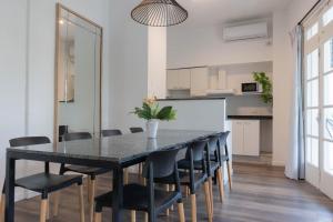 a dining room with a black table and chairs at Fliphaus Niceto Vega 4900 - 3 Bd Event & Party Friendly in Buenos Aires