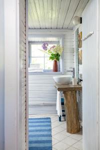 baño con lavabo y jarrón de flores en Adami Country Guesthouse, en Vainupea