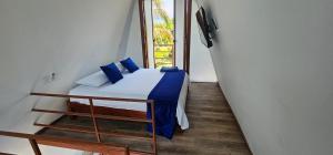 a bedroom with a bed with blue pillows and a window at Finca el diamante in Villavicencio