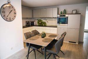 a kitchen with a table and chairs and a clock at Apartments WK in Cologne +16 photos