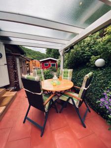 a wooden table and chairs on a patio at Idyllisches Häuschen im Grünen mit Whirlpool in Roßbach