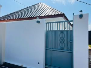 a white garage with a gate and a roof at A Royal Glamourous Apartment in Mwombali