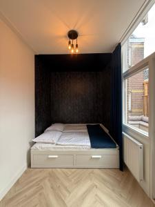 1 dormitorio con 1 cama con pared negra en The Blue House, en Alkmaar
