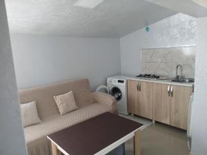 a living room with a couch and a kitchen at mano guest house in Batumi