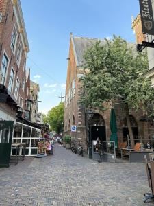 una calle adoquinada en una ciudad con edificios en The Blue House, en Alkmaar