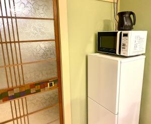 Cucina o angolo cottura di 100 square meters up to 11 people Namba Direct Bus 3 mins JR Osaka Loop Line Station 8 mins Train to Namba 12 mins, USJ 30 mins Kyoto Nara OK