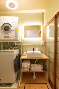un piccolo bagno con lavandino e lavatrice di 100 square meters up to 11 people Namba Direct Bus 3 mins JR Osaka Loop Line Station 8 mins Train to Namba 12 mins, USJ 30 mins Kyoto Nara OK ad Osaka