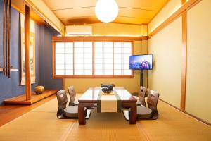 una sala da pranzo con tavolo, sedie e TV di 100 square meters up to 11 people Namba Direct Bus 3 mins JR Osaka Loop Line Station 8 mins Train to Namba 12 mins, USJ 30 mins Kyoto Nara OK ad Osaka