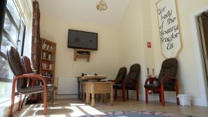 a room with chairs and a table and a tv at Father Peyton Centre, Ballina in Attymass