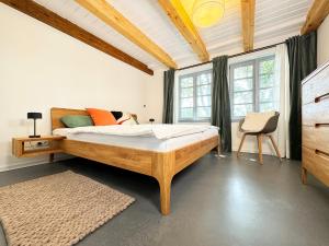 una camera da letto con un letto, una sedia e finestre di Westertilli Eckhuus - modernes, luxuriöses Wohngefühl a Pellworm
