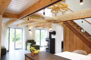 un soggiorno con soffitto in legno e scala di Westertilli Eckhuus - modernes, luxuriöses Wohngefühl a Pellworm