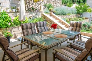 a patio with a glass table and chairs at Oasis apartment in Selca