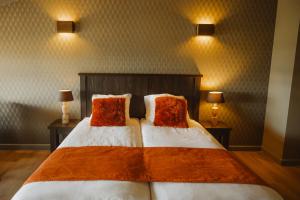 德吕嫩Hotel Restaurant D'n Dries的一间卧室配有一张大床和两个红色枕头